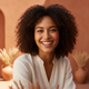 Portrait of a smiling woman in her late 20s, looking at the camera with a happy, trustworthy expression. The background is a 